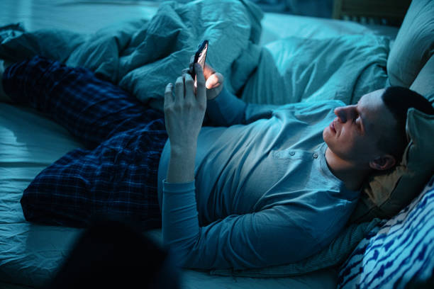 istock Young handicapped man, leg amputee, relaxing in bed late at night and using smartphone before falling asleep 1384751228