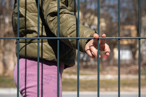 istock Child refugee hand holding a metal fence 1384756972