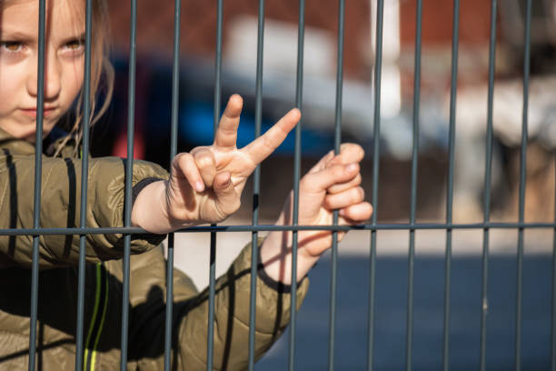 istock Child refugee hand holding a metal fence 1384757029