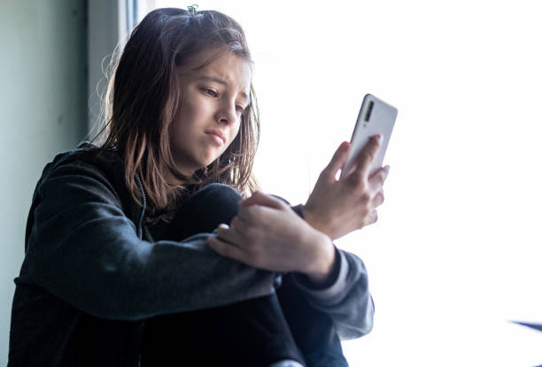 smutna dziewczyna patrząca na telefon - facebook social media twitter iphone zdjęcia i obrazy z banku zdjęć