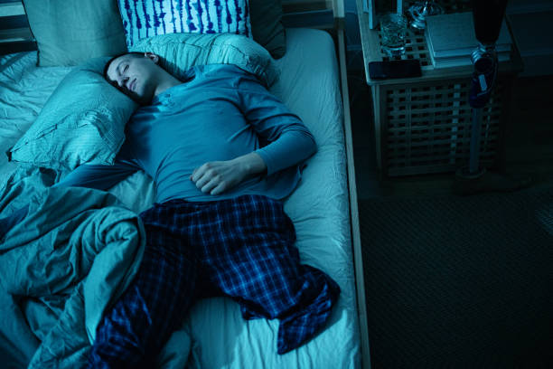 istock Disabled young man, leg amputee sleeping restless in his bed at night 1384763987