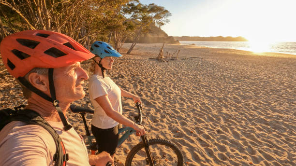 istock Mountain biking couple relax on beach, at sunrise 1384769509