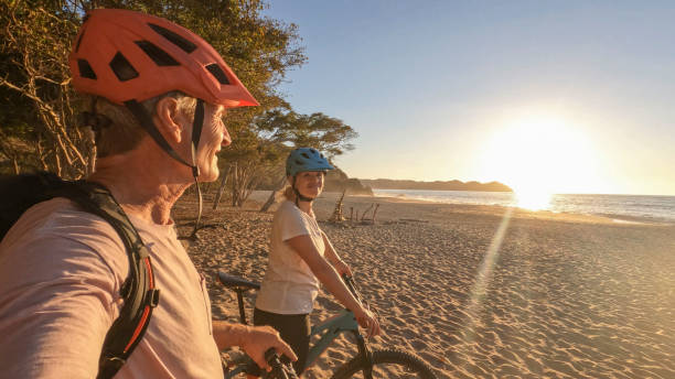 산 자전거 커플 해변에서 휴식을 취하며 일출 - senior couple cycling beach bicycle 뉴스 사진 이미지