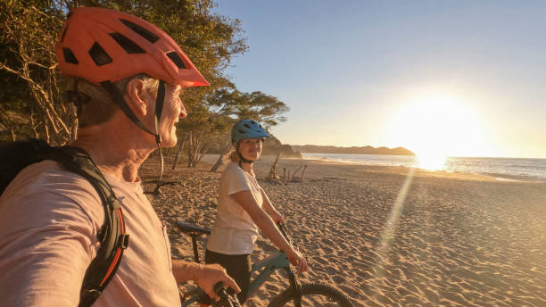 istock Mountain biking couple relax on beach, at sunrise 1384769511