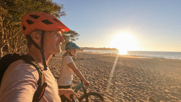 istock Mountain biking couple relax on beach, at sunrise 1384769520