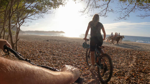 istock Female mountain biker follows trail onto beach 1384769726