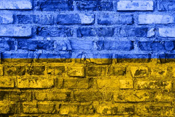 Flag of Ukraine painted on old grunge brick wall, background texture