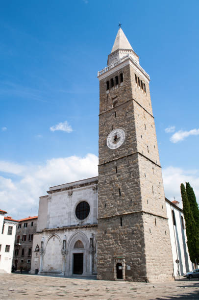 Church with a tall tower in the city of Koper in Slovenia. Old stone tower near the church right in the center of Koper in Slovenia. Historic monumental building in a port city in Europe. koper slovenia stock pictures, royalty-free photos & images