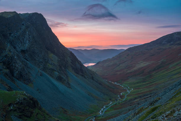 Stunning colorful landscape image of view down Honister Pass to Buttermere from Dale Head in Lake District during Autumn sunset stock photo
