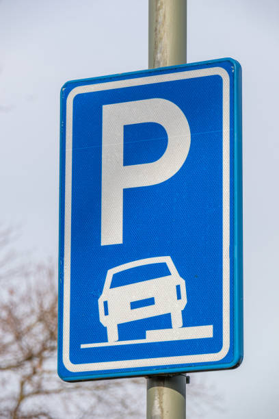 istock Car parking sign on part of the sidewalk, blue rectangular metal vertical plate with a drawing of a car on the sidewalk 1384786046
