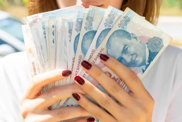 Girl holding banknotes / money in her hand