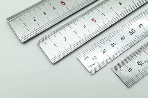 Iron ruler close-up on a white background. Stainless steel ruler. Working tools made of metal and stationery. Selective focus, isolated on white.