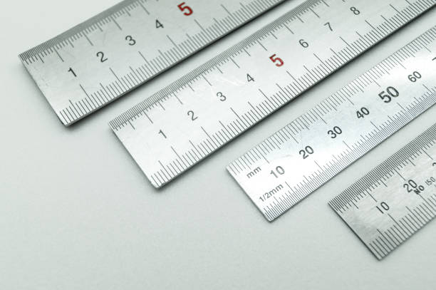 iron ruler close-up on a white background. stainless steel ruler. working tools made of metal and stationery. selective focus, isolated on white - millimetre imagens e fotografias de stock