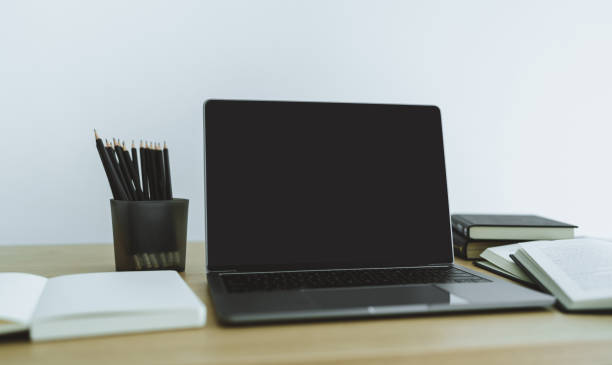 istock Blank screen laptop with book or textbook. Business and education 1384797082