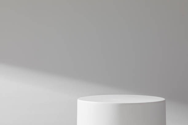 istock White cylindrical stone podium on a background of concrete wall 1384799515