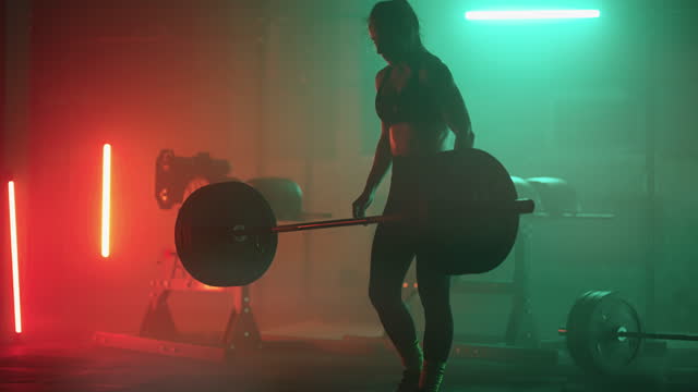 powerful woman is lifting barbell in gym, powerlifting and bodybuilding training for keeping fit