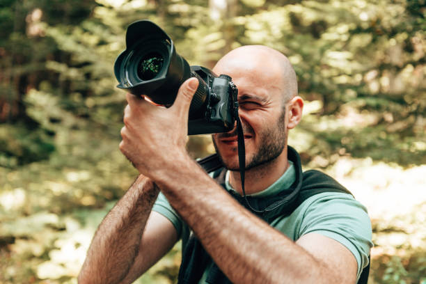 istock hapiness bald man taking a picture in the forest 1384803558