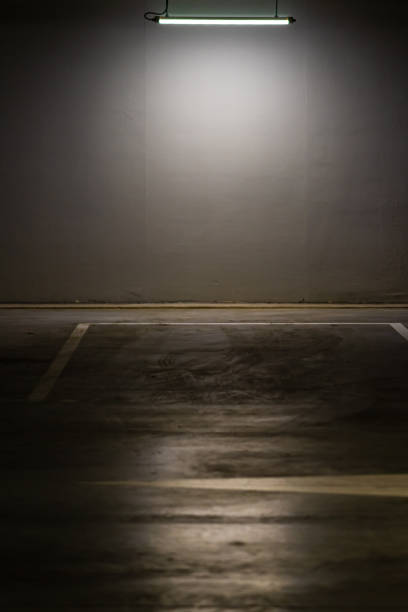 istock Empty parking lot with overhead dim light, underground parking garage. 1384807615