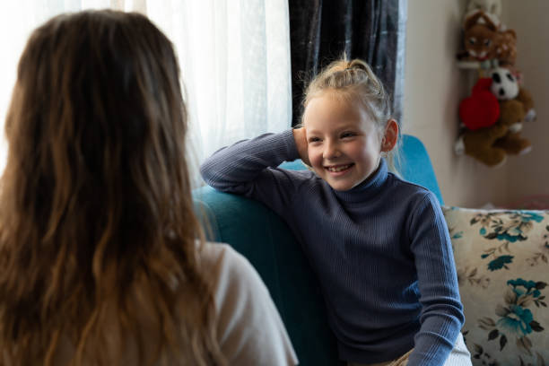 istock Daughter sitting on sofa talking with mom 1384809499