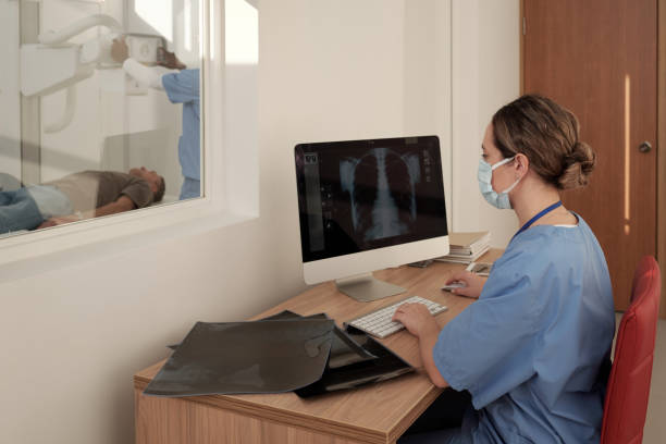 istock Young female radiologist sitting by workplace in front of computer 1384820853