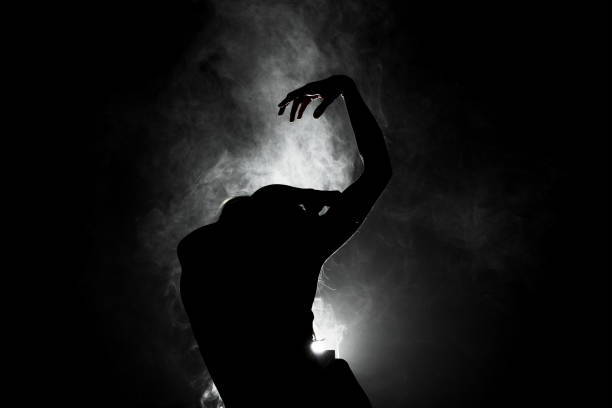istock silhouette modern ballet dancer posing on dark background with smoke 1384821925
