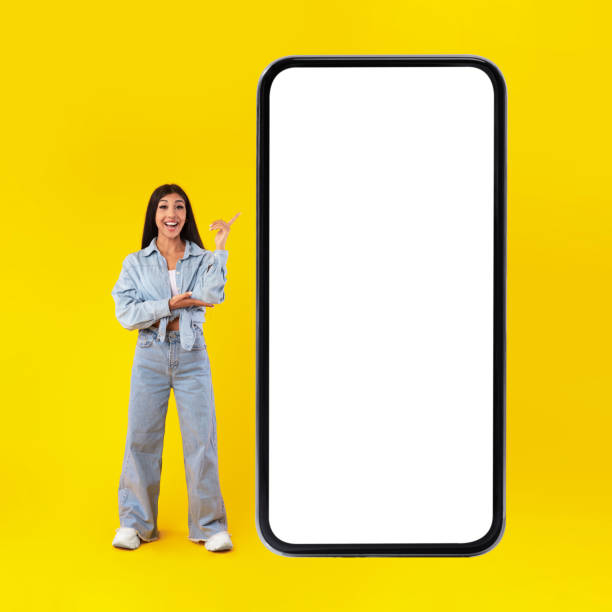 istock Happy lady pointing at mobile phone screen 1384825424