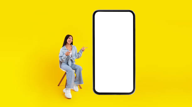 istock Happy lady pointing at mobile phone screen 1384826822