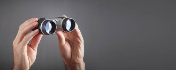 istock Male hands showing binoculars. Hiking Accessory 1384828215