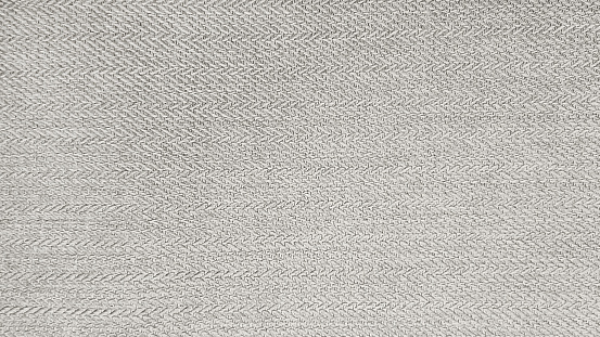 grey beige cashmere fabric in herringbone tweed pattern, virgin wool fabric texture use as background. expensive men's suit of fabric. interior drapery or upholstery background.