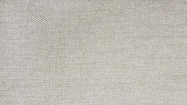 grey beige cashmere fabric in herringbone tweed pattern, virgin wool fabric texture use as background. expensive men's suit of fabric. interior drapery or upholstery background.