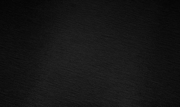 istock close up black textile mesh background with blank space for design. abstract dark black foil background with light reflections. black textured wall. macro drapery luxury texture. 1384836495