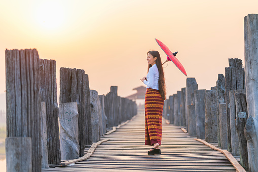 A Burmese girl walks on a bridge at a major tourist attraction in Mandalay Province, Myanmar.