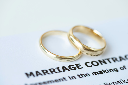 Weeding rings on marriage contract papers.