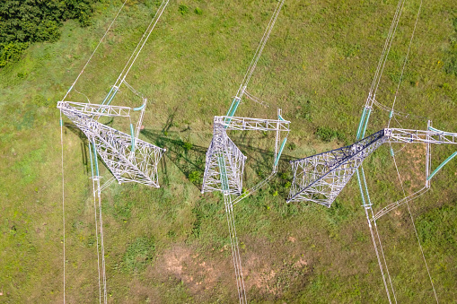 Top view of High voltage power line on industrial electricity line tower for electrification rural countryside.