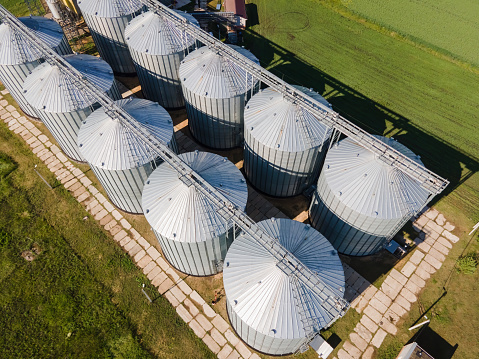 Aerial view of agricultural grain silos. Cereal plants crop storage tanks