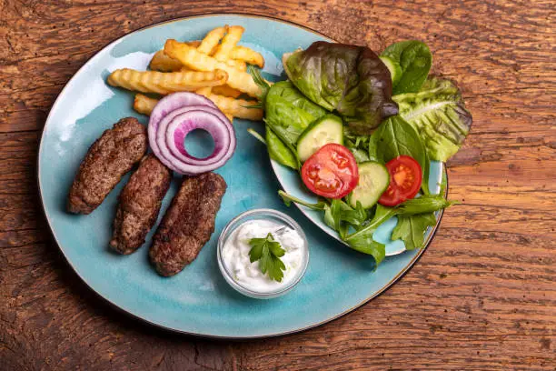 cevapcici with fries on wood