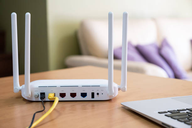 istock Selective focus at router. Internet router on working table with living room no people at the background. Fast and high speed internet connection from fiber line with LAN cable connection. 1384857784