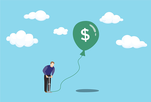Inflation concept with man pumping air with bicycle pump into floating balloon with United States currency $ symbol on balloon, blue sky with white clouds, infographic for inflation, recession, financial crisis, overvalued stock market, money inflation, etc.