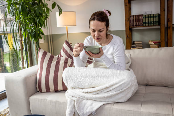 istock Woman eating soup on a sofa bed 1384863111