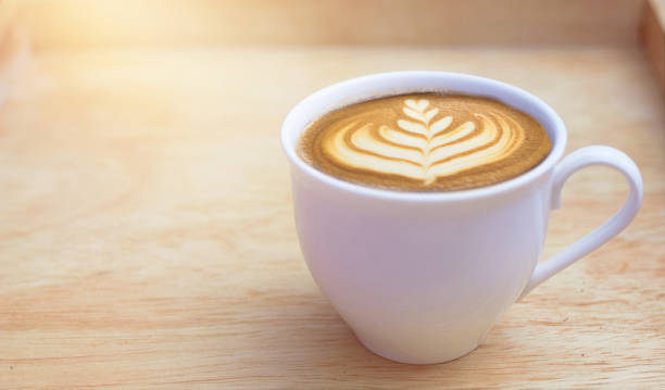 istock hot latte coffee cup in wooden background 1384863198