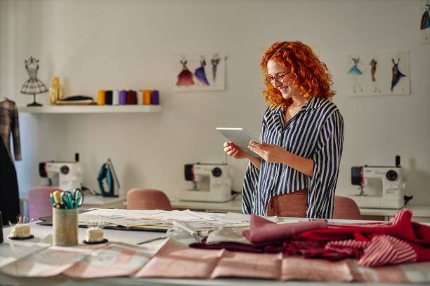 istock Female fashion designer using digital tablet at work 1384868112