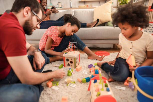 istock Two multiracial sisters sitting on floor and playing with interactive toys 1384868159