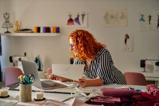 istock Ginger fashion designer working in studio 1384868241