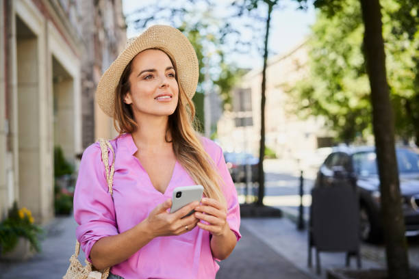 istock A Woman looks around while exploring the city using her smartphone 1384870866