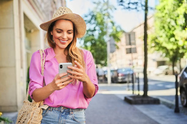 Smiling woman using smartphone on the street