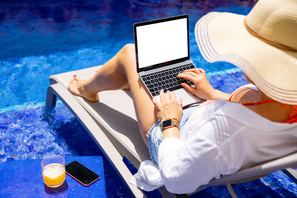 istock Woman working on laptop by the pool 1384871642