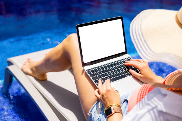 istock Woman working with laptop by the pool, screen mockup 1384871664