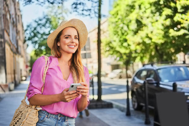 istock Beautiful woman using smartphone looking for direction while visiting European city during summer vacation 1384871826