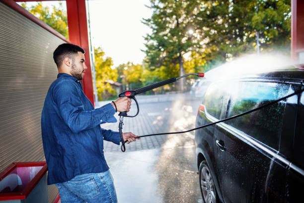 istock Young men washing car at fuel pump by himself 1384874537