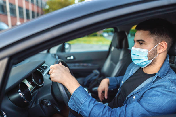istock Young men with protective face mask driving taxi 1384874632